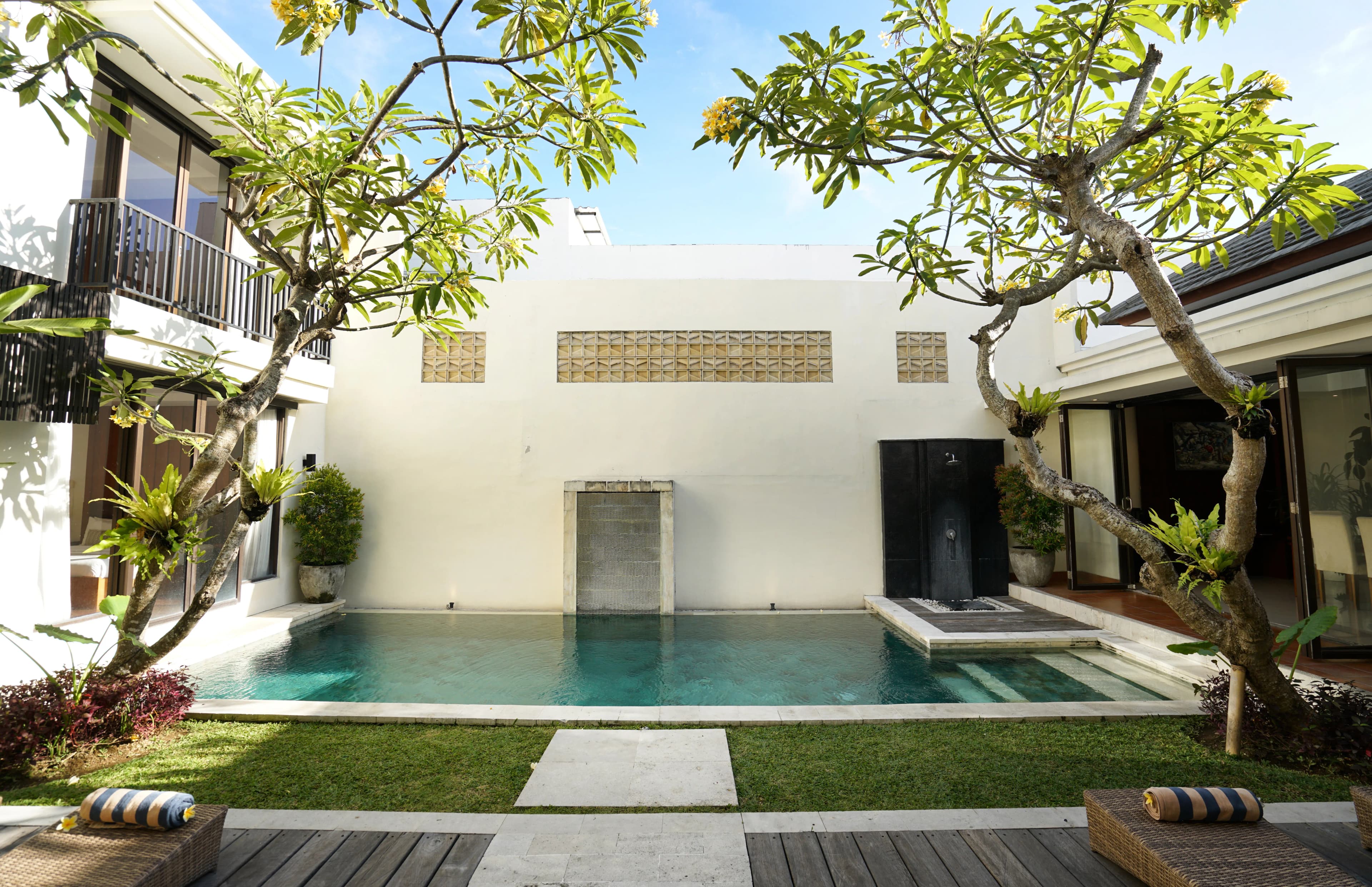 Modern villa with private pool in Bali, surrounded by tropical greenery.