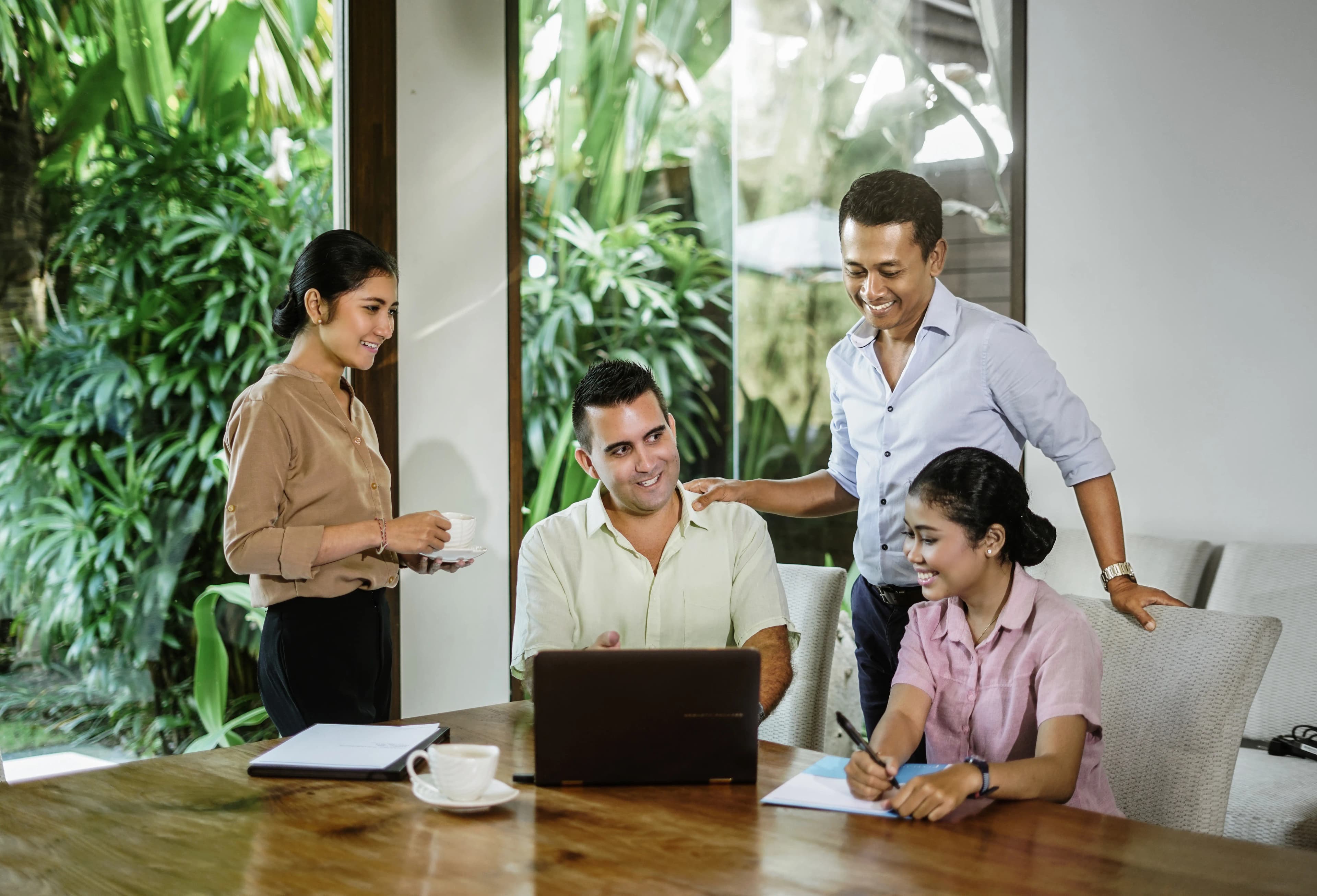 Professional team having a relaxed discussion in a tropical villa office in Bali.